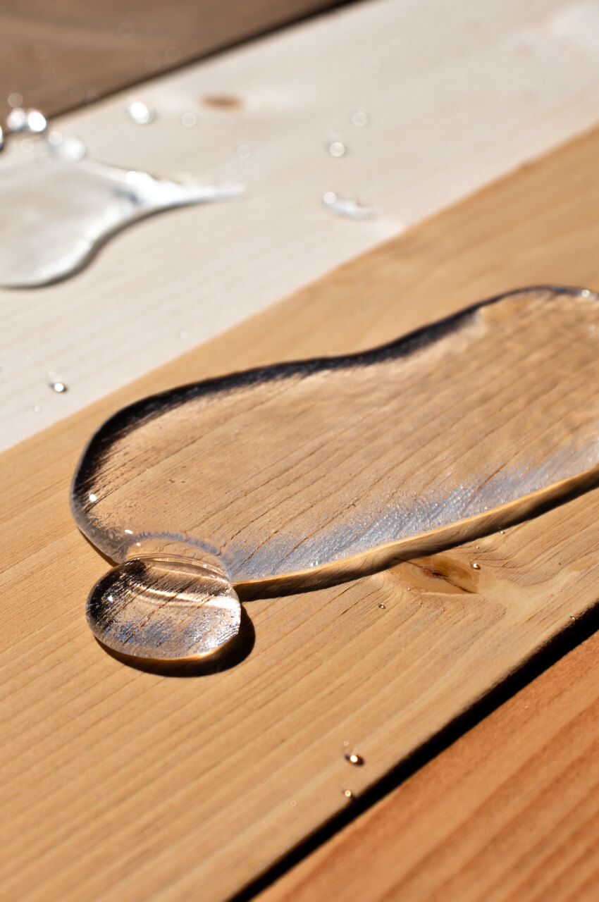 Goccia di acqua che non bagna il legno reso impermeabile da un impregnante al solvente